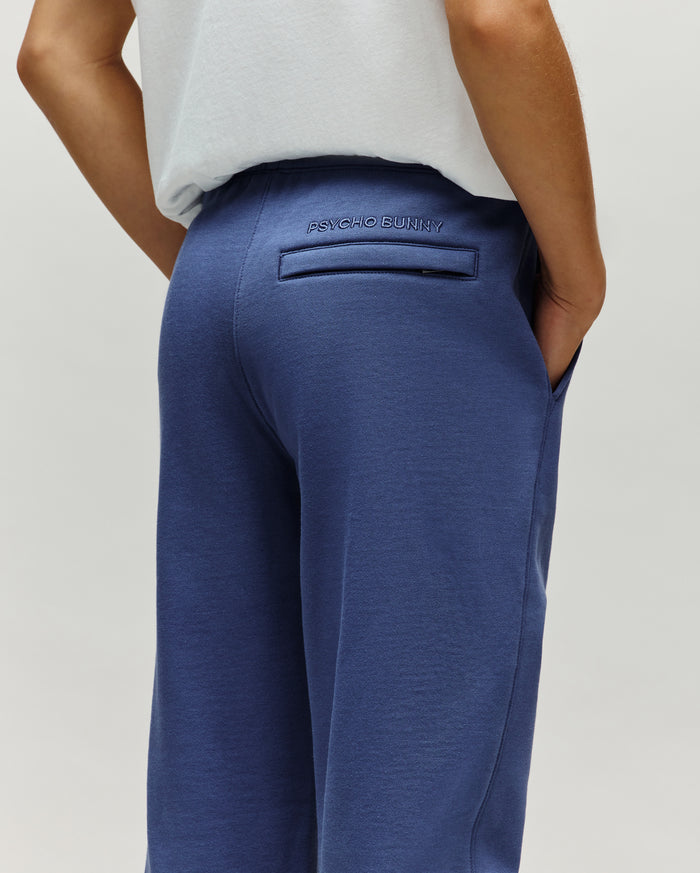 Kids Indigo Ski Bunny Sweatpant in indigo blue, crafted from soft french terry with a relaxed fit, featuring an embroidered Psycho Bunny text logo above a back welt pocket and convenient side pockets.