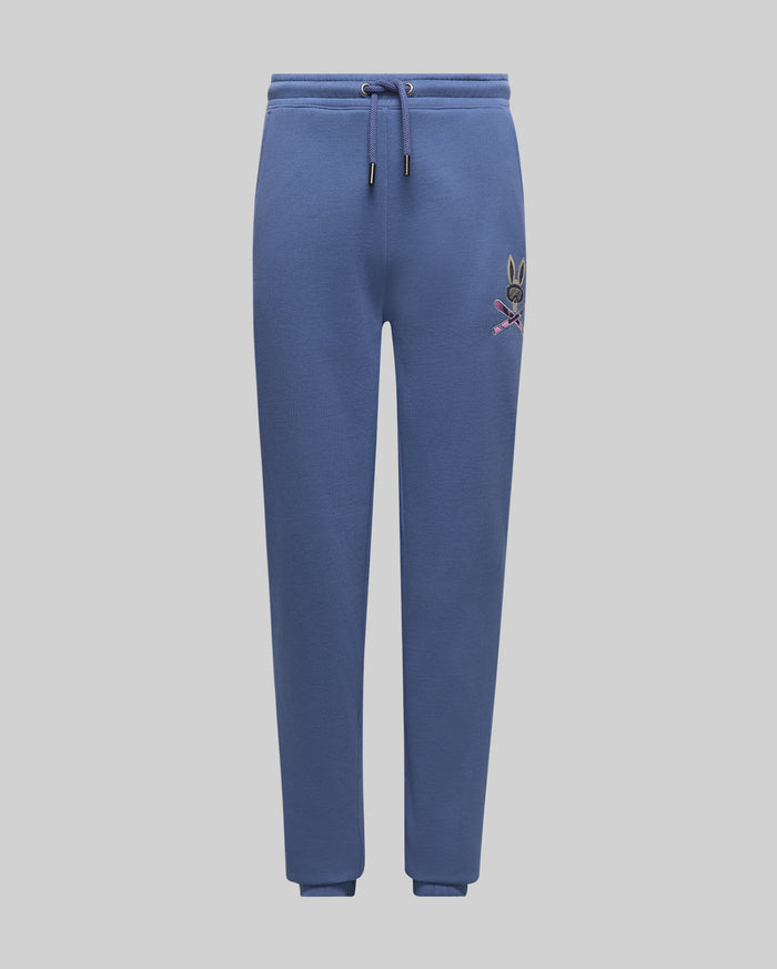 Kids Indigo Ski Bunny Sweatpant, a relaxed fit indigo blue French terry sweatpant featuring a vibrant embroidered Psycho Bunny ski logo on the left thigh and an adjustable drawstring waist.