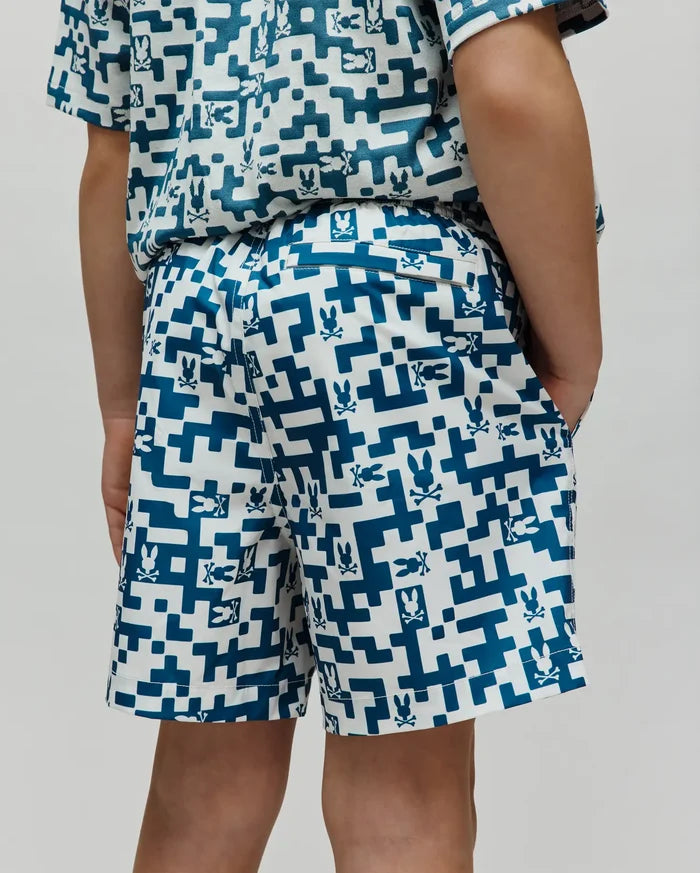 Kids Josh Swim Trunk in white with a teal pixelated geometric pattern featuring small Psycho Bunny skull logos throughout, a classic fit, and smooth quick-dry fabric.