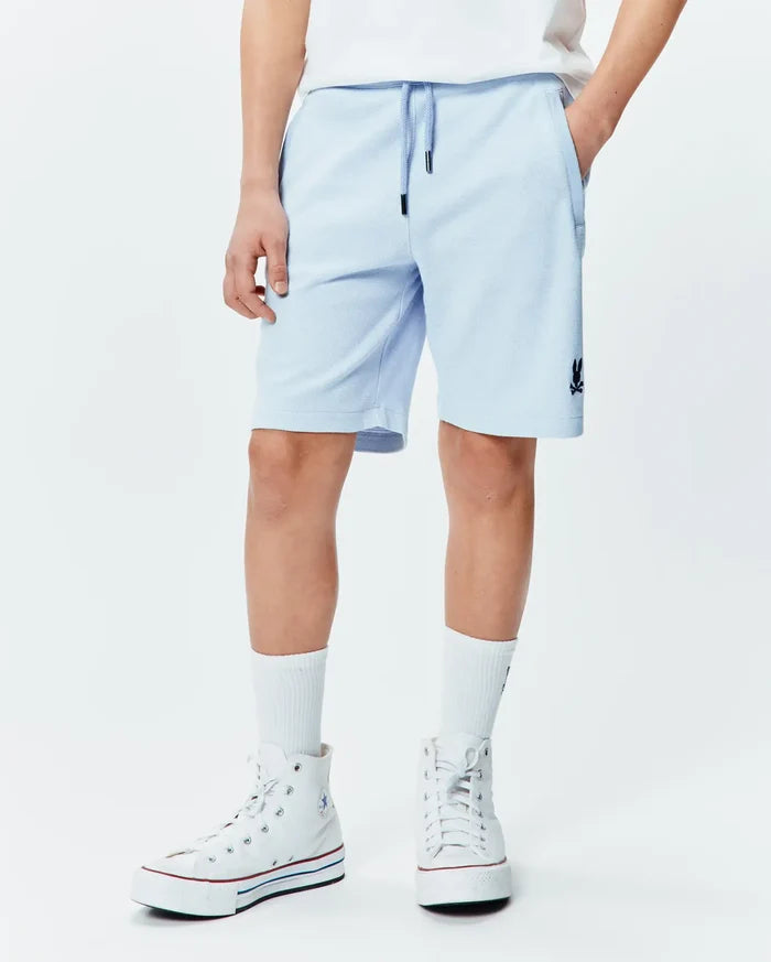 Kids Keith Short 3 1/2, light blue pique knit, relaxed fit with drawstring waist, side pockets, and a small embroidered navy Psycho Bunny skull logo on the left leg.