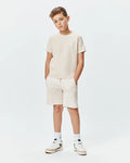 Psycho Bunny kids beige jersey t-shirt and Kids Keith Short 3 1/2 French terry shorts. Both feature white embroidered bunny skull logos, on the left chest and left thigh.