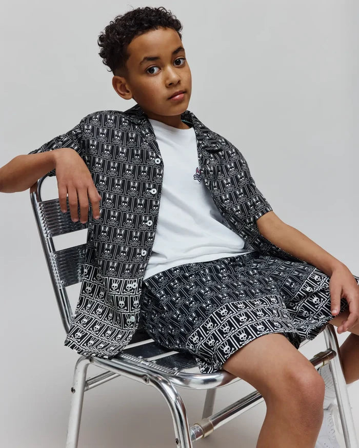 Kids Keon Tencel Shirt, a relaxed fit black and white allover Psycho Bunny skull pattern button-up, over a white jersey tee with a small embroidered logo, and matching Tencel shorts.