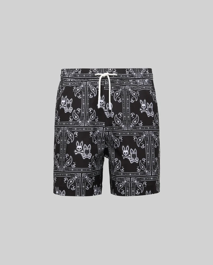 Kids Luke Swim Trunk in black with an all-over white bandana paisley pattern featuring repeated Psycho Bunny skull logos and a white drawstring.