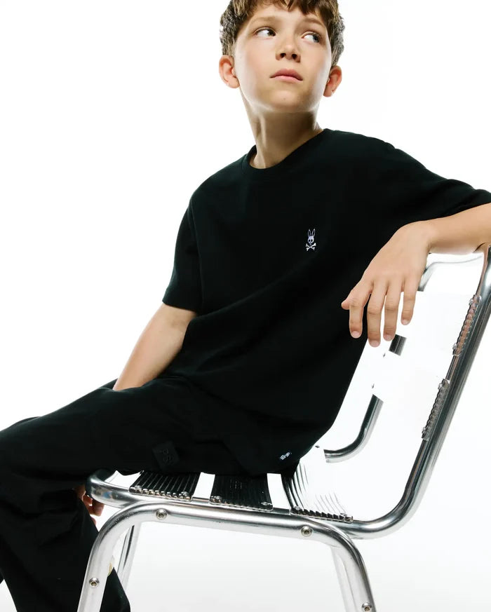 Black Kids Maxton Waffle Tee with a classic fit, featuring a subtle waffle knit texture and a small embroidered white Psycho Bunny skull logo on the left chest.