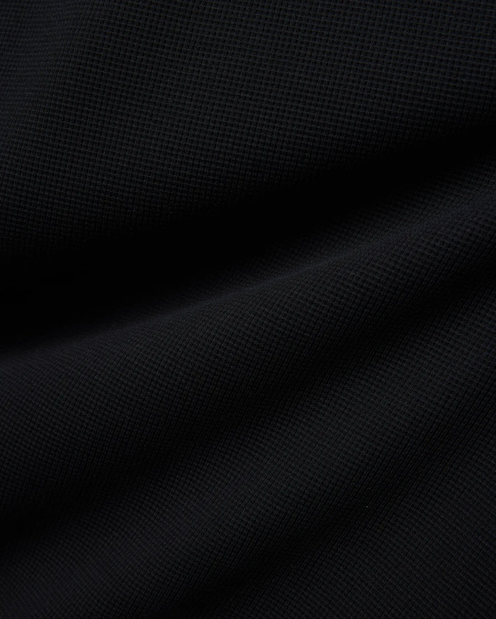Premium Kids Maxton Waffle Tee in a deep black, featuring a distinct, soft waffle knit fabric texture with subtle raised squares and gentle folds, ensuring comfortable, refined style.