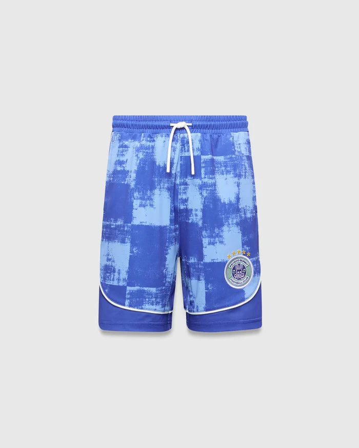 Kids Micah Soccer Short in blue with a distressed light blue checkered pattern, white drawstring, and white piping. Features a circular Psycho Bunny Football Club logo with a bunny skull and stars on the right leg.
