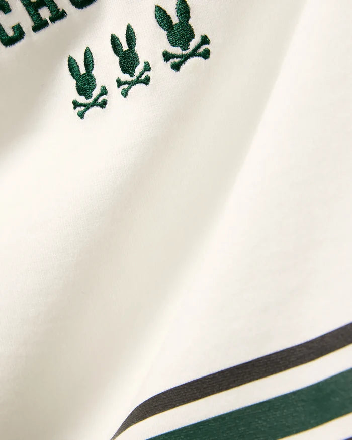 Kids Mike Graphic Jersey Tee in white jersey knit, featuring multiple small embroidered dark green Psycho Bunny skull logos and a bottom stripe design with dark green and black accents.