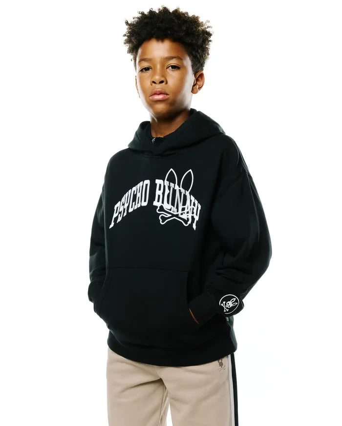 Kids Nathaniel Relaxed Hoodie in black French terry, featuring a large white arched Psycho Bunny text and skull logo on the chest, plus a small circular white skull logo on the left sleeve cuff.