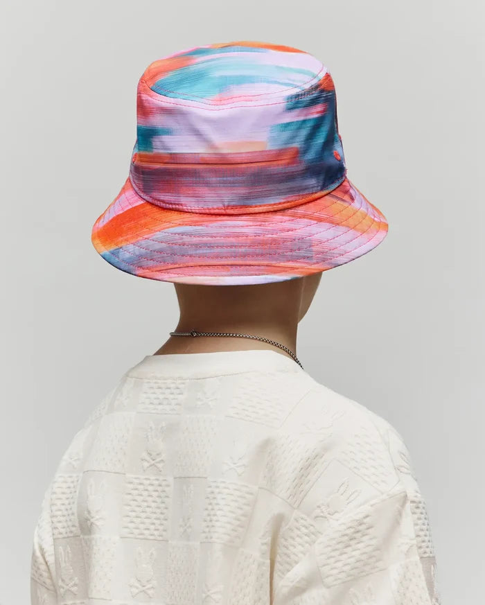 Kids Raphael Bucket Hat in vibrant multi-color abstract print paired with an off-white relaxed fit textured knit t-shirt featuring an all-over checkerboard Psycho Bunny skull logo pattern.