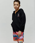 Kids Raphael French Terry Full Zip Hoodie in black, featuring a relaxed fit and a small, embroidered, multi-colored Psycho Bunny skull and crossbones logo on the left chest.