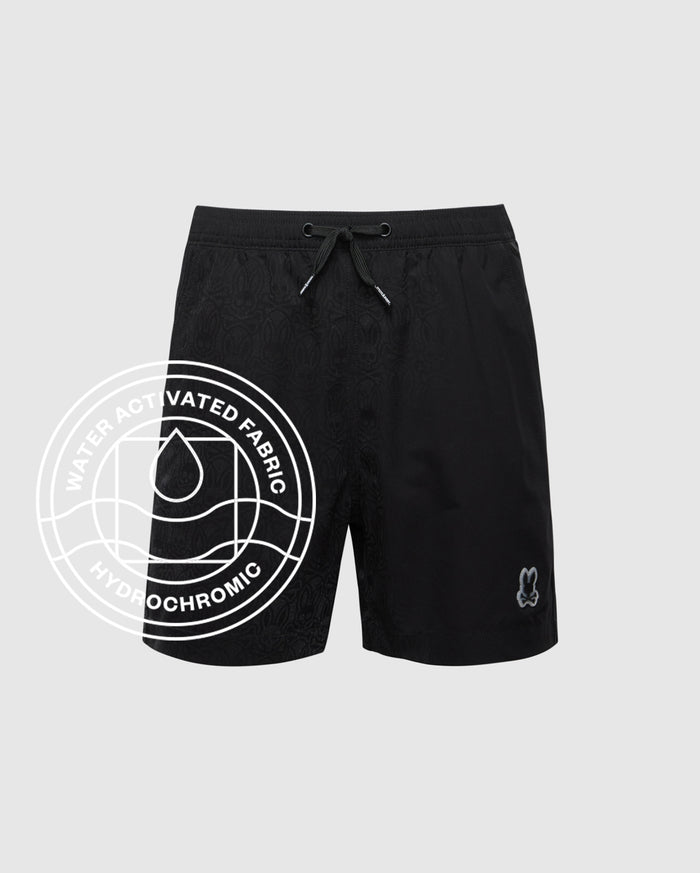 The Psycho Bunny KIDS SAMOS HYDROCHROMIC SWIM TRUNK (B0W453F200) features a subtle pattern, quick-dry fabric, drawstring waist, and bunny logo. "WATER ACTIVATED FABRIC HYDROCHROMIC" overlay with water droplet graphic included.