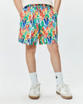 Kids Tanner Swim Trunk with a vibrant multi-color all-over print of Psycho Bunny skull and crossbones logos in red, orange, yellow, green, blue, and white, featuring a relaxed fit and elastic waistband.