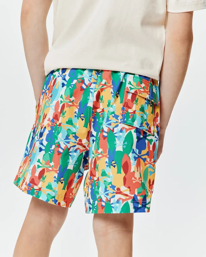 Kids Tanner Swim Trunk in vibrant multi-color, featuring an all-over abstract print of Psycho Bunny skull logos and bunny silhouettes, with a relaxed fit and a cargo pocket.