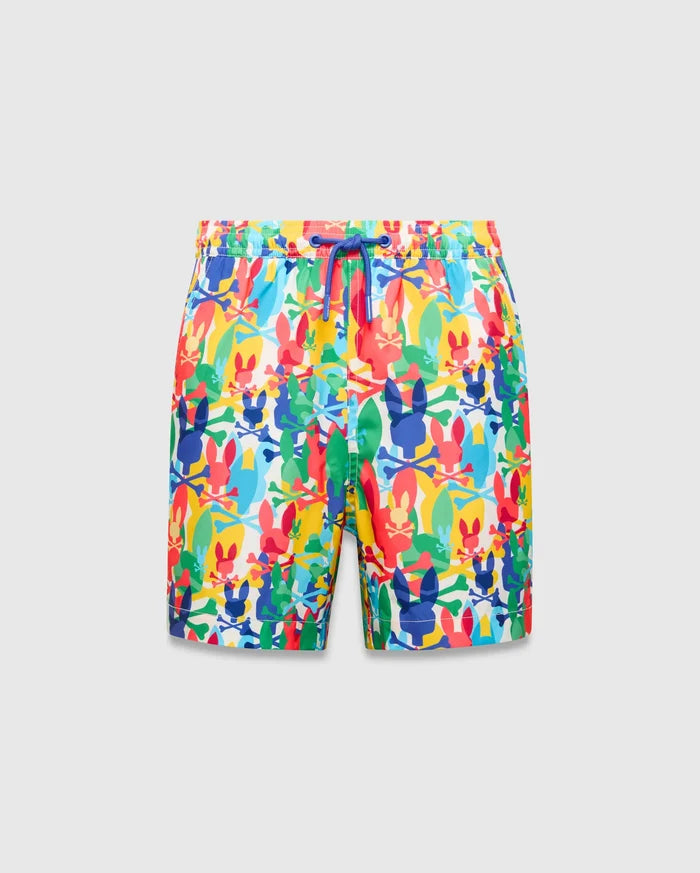 Kids Tanner Swim Trunk with a vibrant all-over print of colorful Psycho Bunny skull logos, crossbones, and surfboards on a white background, featuring a royal blue drawstring.