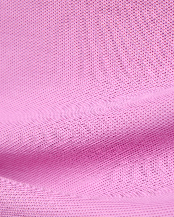 Kids Taylor Pique Tee in vibrant pink, showcasing its classic pique knit texture. This premium Psycho Bunny t-shirt embodies refined streetwear with its signature embroidered bunny skull logo.