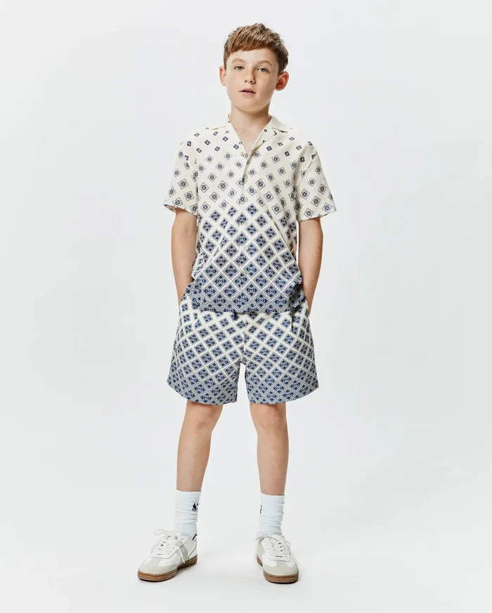 Psycho Bunny Kids Tobias Tencel Shirt and matching shorts, cream with a blue geometric diamond pattern, relaxed fit, featuring a gradient effect on the shirt.