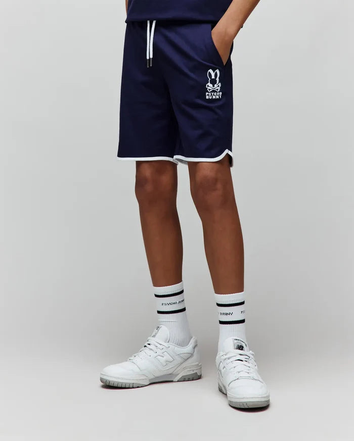 Kids Toby Short, navy smooth knit with a relaxed fit, featuring white piping on the hem, white drawstrings, and a medium-sized white printed Psycho Bunny skull logo on the left thigh.