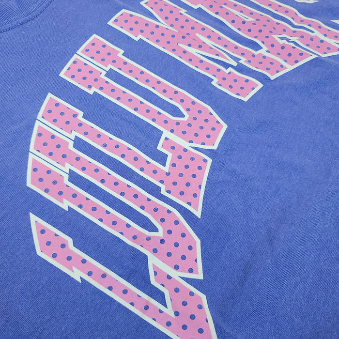 Close-up detail of pink polka dot “LULU MAC” graphic printed on flo blue Lulu Mac short sleeve t-shirt fabric.