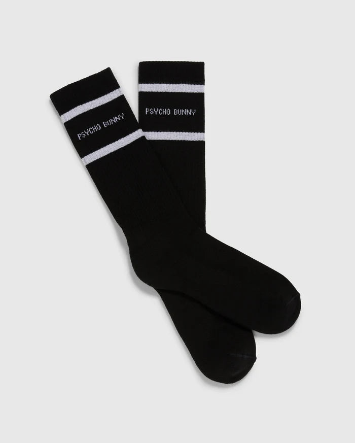 Introducing the MENS 3 PACK SPORT SOCK - B6F997D200 by Psycho Bunny: This pack includes 3 pairs of black crew sport socks, each adorned with white stripes near the top. Crafted from luxurious Peruvian pima cotton, these socks feature the "Psycho Bunny" text in white just below the stripes, all set against a plain light gray backdrop.