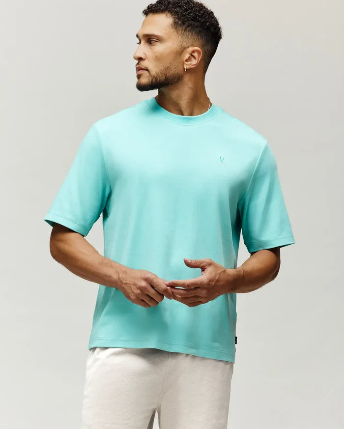 Mens Adam Interlock Tee in vibrant aqua, featuring a relaxed fit, smooth interlock knit, and a small tonal embroidered Psycho Bunny skull logo on the left chest.