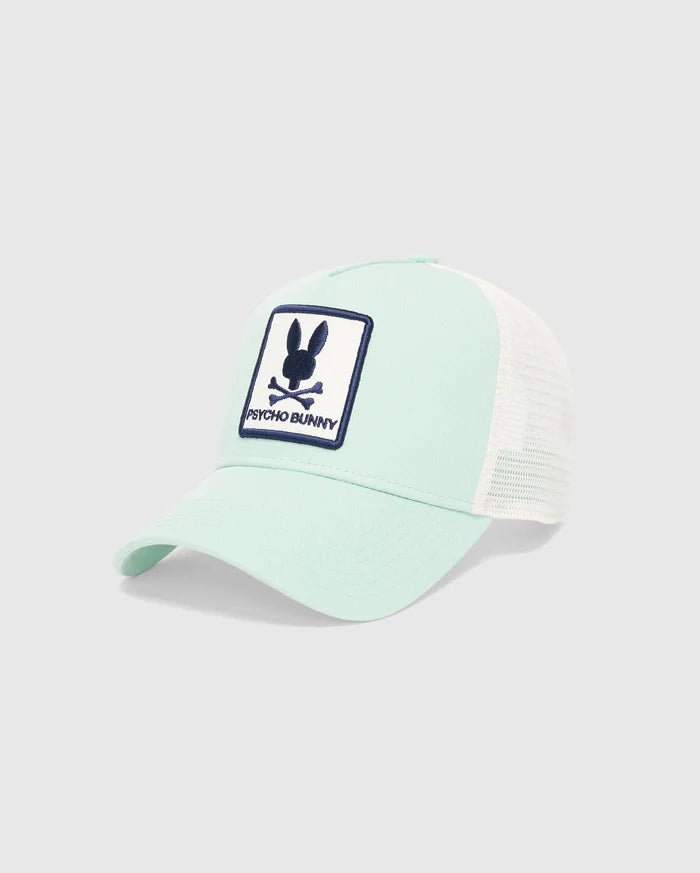 Mens Adamo Trucker Cap in mint green with a white mesh back. Features a large, embroidered navy blue and white Psycho Bunny skull logo patch on the front.