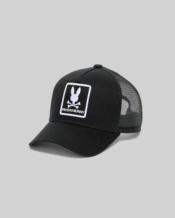 Mens Adamo Trucker Cap, black cotton twill front with a large white embroidered Psycho Bunny skull logo and text in a rectangular border, featuring a breathable black mesh back.