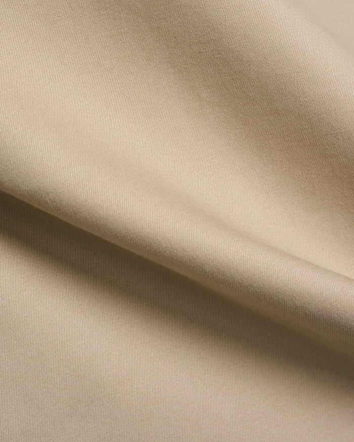 Mens Aidan Chino Pant in a warm khaki beige, featuring a refined, durable twill weave fabric with visible diagonal lines and a smooth, soft texture, draped in gentle folds.