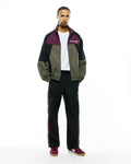 Mens Alder Nylon Colorblock Jacket, a relaxed fit crinkled nylon jacket in dark green, black, and plum, featuring a white Psycho Bunny text logo on the left chest.