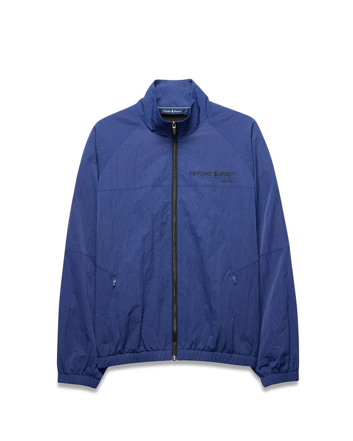 Mens Alder Nylon Jacket, a royal blue full-zip jacket with a crinkled texture, features a stand collar, elastic cuffs/hem, zippered pockets, and a large black PSYCHO BUNNY® DESIGNED FOR DISRUPTION text logo on the chest.
