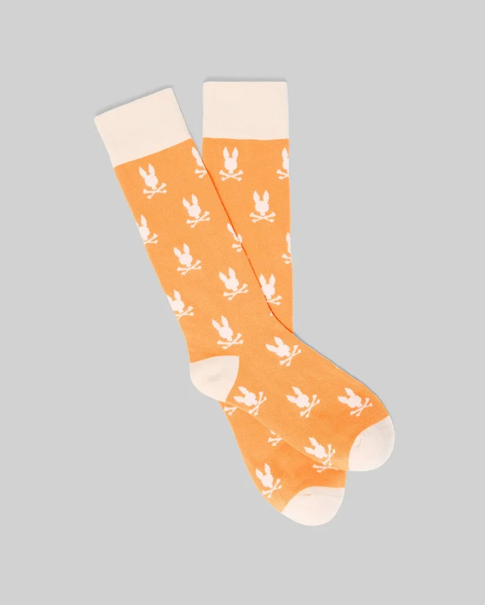 Mens All Over Bunny Dress Sock in vibrant orange with a cream cuff, heel, and toe, featuring an all-over cream Psycho Bunny skull logo pattern on a smooth knit fabric.