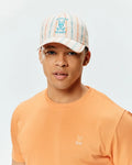 Mens Antoine Seersucker Baseball Cap with cream, blue, and orange stripes, featuring a large embroidered Psycho Bunny logo, paired with a peach classic fit jersey t-shirt with a small embroidered Psycho Bunny logo.