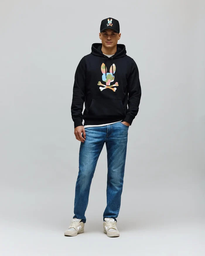 Mens Ara Hoodie, a black classic fit French terry hoodie featuring a large, colorful camouflage Psycho Bunny skull logo with white crossbones on the chest, plus a front pouch pocket and drawstring hood.