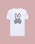 The Psycho Bunny MENS ARCHIVE BUNNY GRAPHIC TEE (MT0200031) is a white Pima cotton shirt with a bold front graphic of a skull with bunny ears and crossed bones, shown on a light pink background.