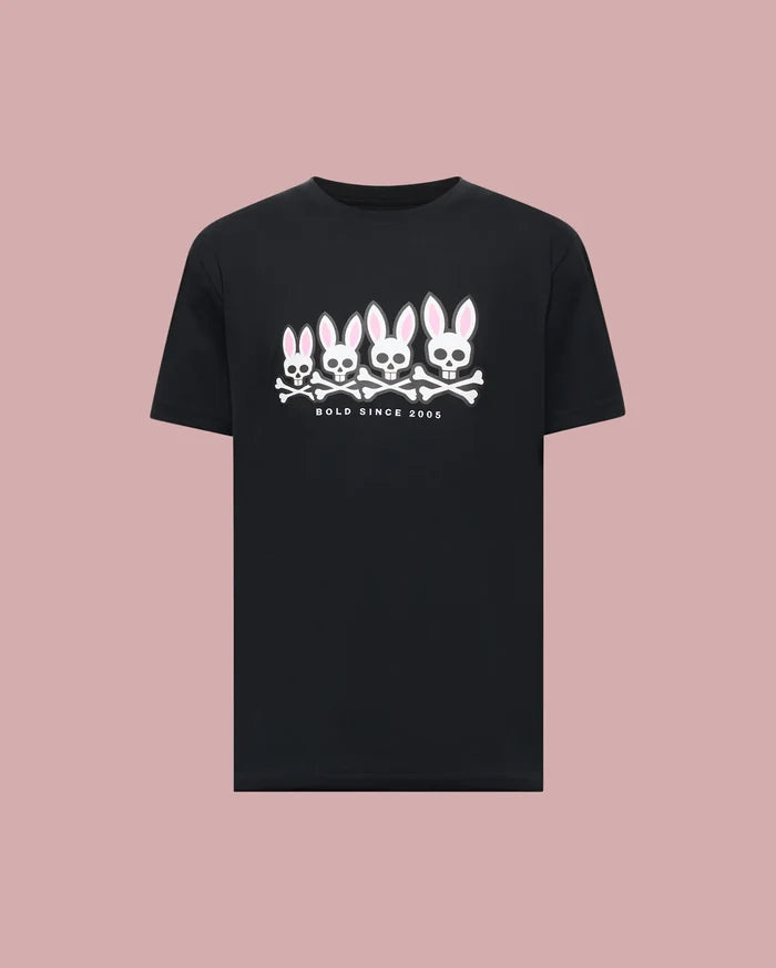 The Psycho Bunny MENS ARCHIVE GRADIANT BUNNY GRAPHIC TEE (MT0200029) is a black tee featuring four iconic Bunny skull and crossbones with pink ears above "BOLD SINCE 2005," set against a plain pink background.