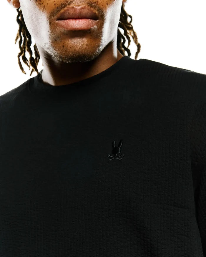 Mens Arlen Relaxed Seersucker Tee, black, featuring a textured seersucker fabric and a small, tonal embroidered Psycho Bunny skull logo on the left chest.