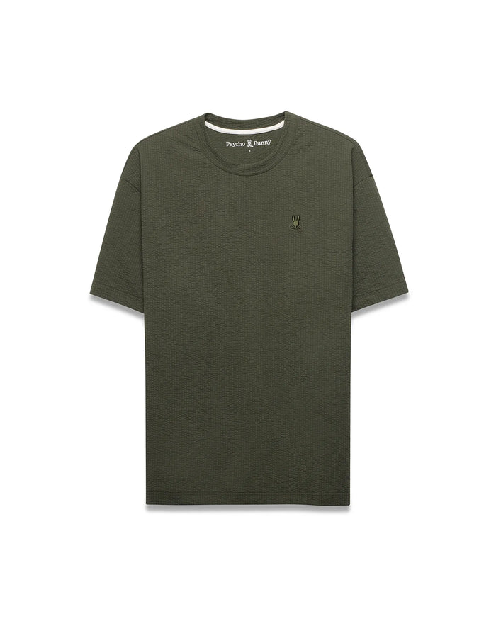 Mens Arlen Relaxed Seersucker Tee in dark olive green, featuring a textured seersucker fabric and a small, embroidered Psycho Bunny skull logo on the left chest.