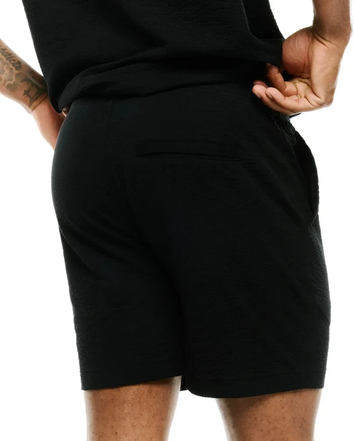 Mens Arlen Seersucker Short, a premium black short with a distinctive puckered seersucker texture, offering a relaxed fit and featuring a discreet back welt pocket, embodying refined streetwear style.