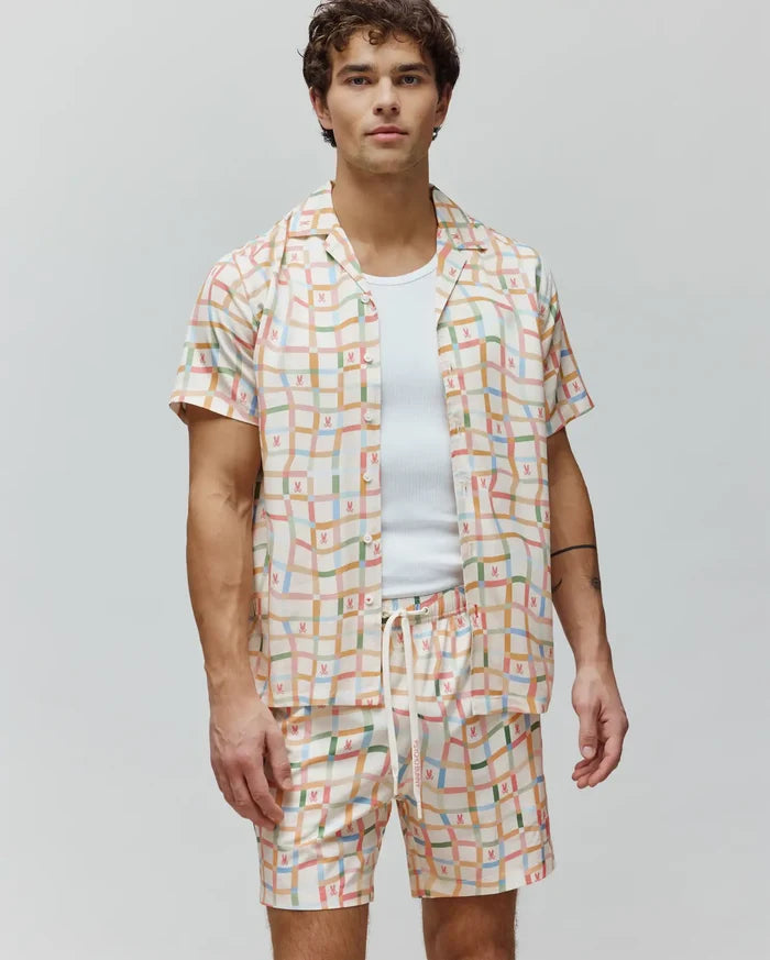 Mens Atlas Tencel Shirt, a relaxed fit cream short-sleeve button-up with a vibrant multicolor grid pattern and repeated small Psycho Bunny skull logos.