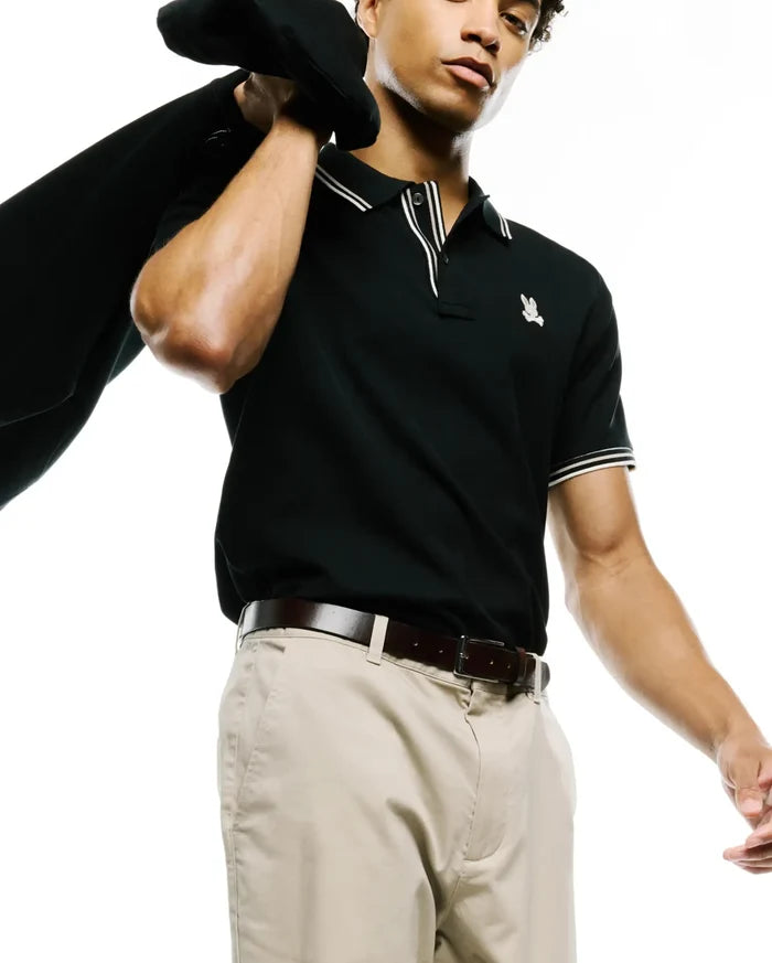 MENS ATLEY PIQUE POLO, a classic fit black pique polo with white double-stripe tipped collar and cuffs, featuring a small embroidered Psycho Bunny skull logo on the left chest.