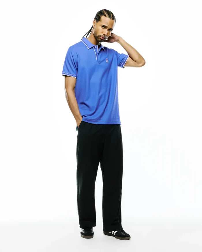 Mens Atley Pique Polo in vibrant blue, featuring a classic fit, white tipping on the collar and sleeve cuffs, and a small embroidered Psycho Bunny skull logo on the left chest.