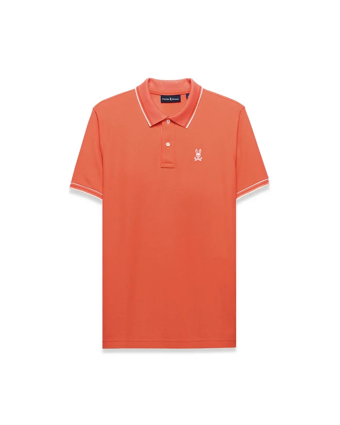Men's Atley Pima Pique Polo in vibrant coral orange, featuring a classic fit, pique texture, white tipping on the ribbed collar and cuffs, and a small embroidered white Psycho Bunny skull logo on the left chest.