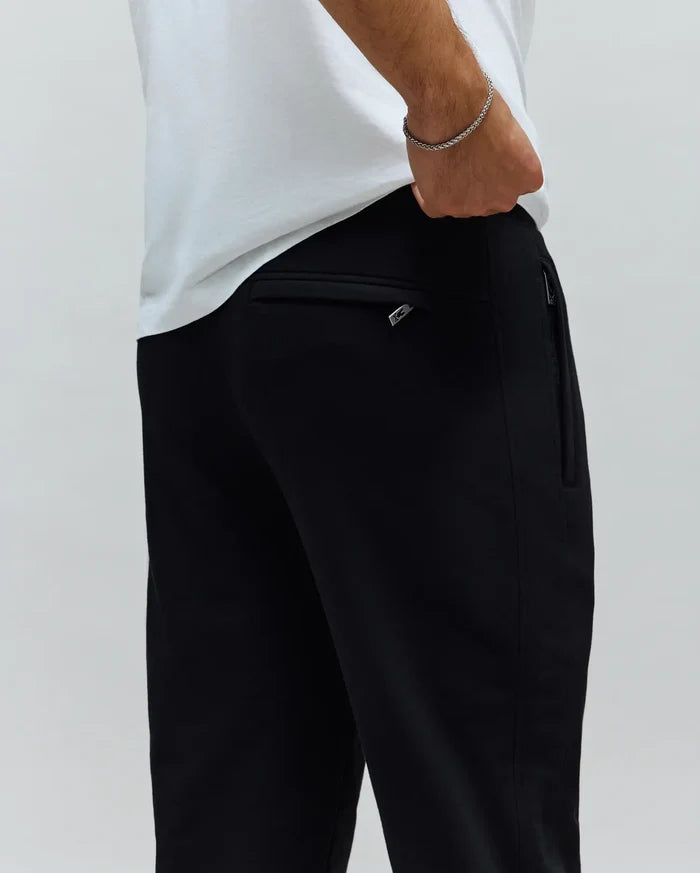 Mens Barry Joggers. Black, relaxed fit, smooth knit joggers featuring a back pocket with a silver Psycho Bunny logo zipper pull and a side zipper pocket.