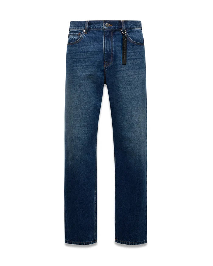 Mens Beck Denim Relaxed Pant in medium blue denim with a faded wash, orange contrast stitching, and a black Psycho Bunny branded tag with blue text on the front belt loop.