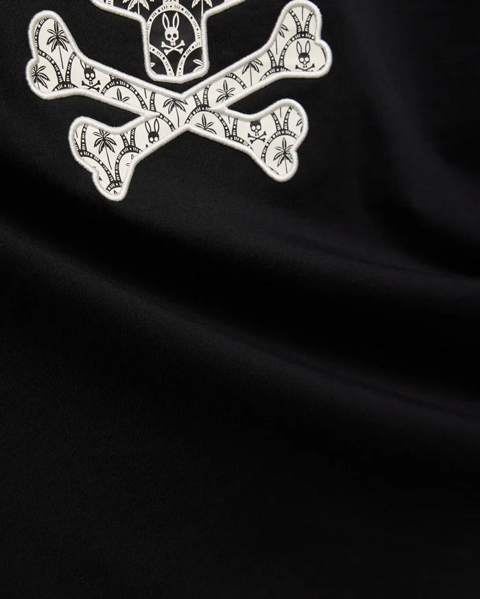 Mens Brad Graphic Tee, black smooth jersey with a large white embroidered Psycho Bunny skull and crossbones graphic, featuring tropical palm trees and mini bunny skulls within the bones.