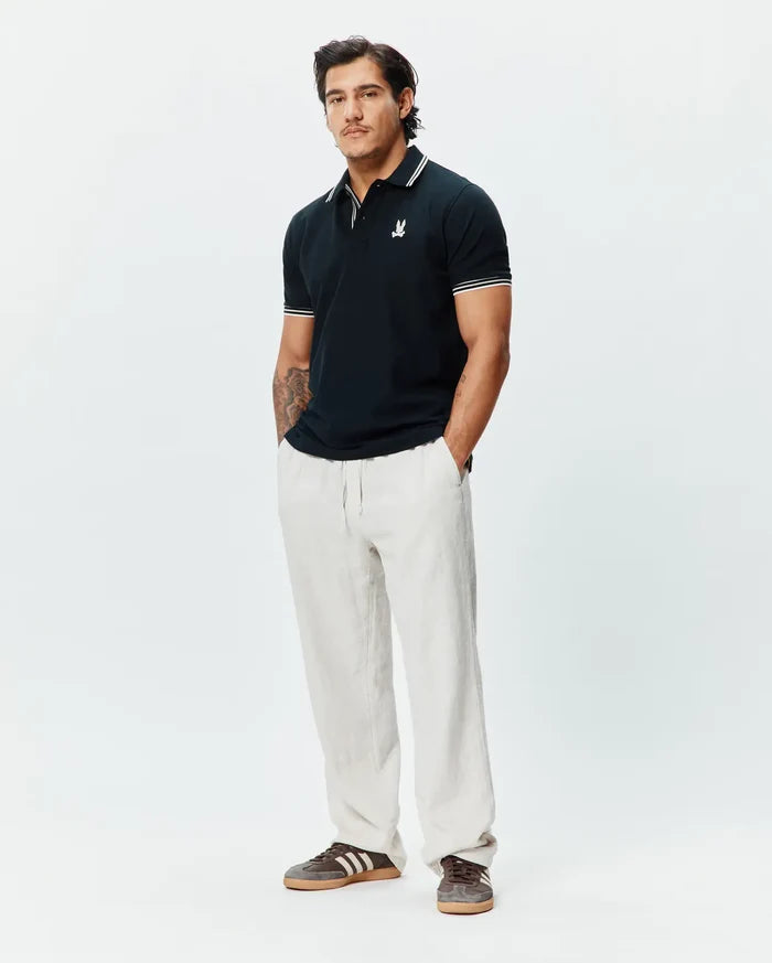 Mens Brad Pique Polo in navy, featuring a classic fit, pique texture, white tipped collar and cuffs, and a small embroidered white Psycho Bunny skull logo on the left chest.