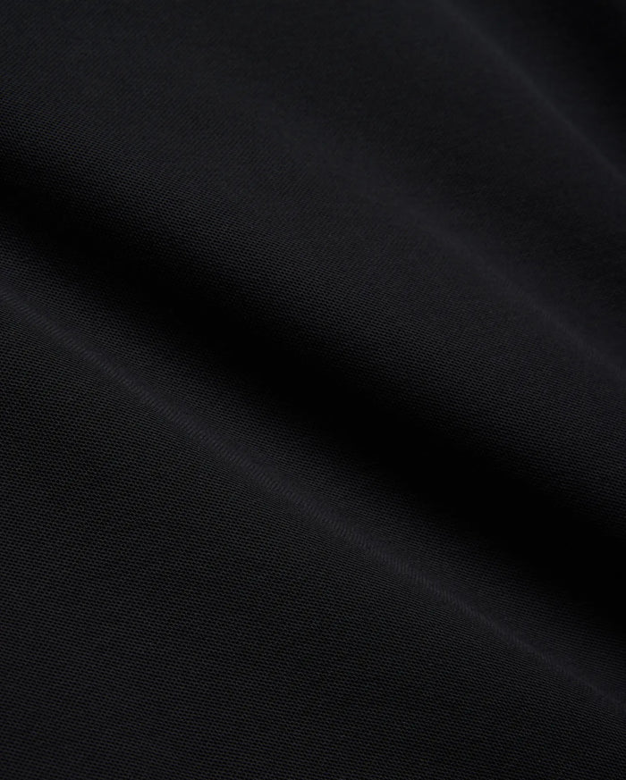 Mens Brad Pique Polo, a premium black pique knit fabric with a subtle, textured weave, showcasing the refined quality and classic style of Psycho Bunny menswear.