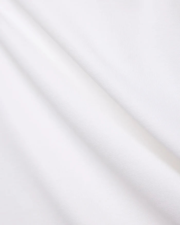 Crisp White Mens Brad Pique Polo fabric, highlighting its distinctive textured pique weave, soft, luxurious feel, and elegant folds, embodying premium Psycho Bunny menswear.