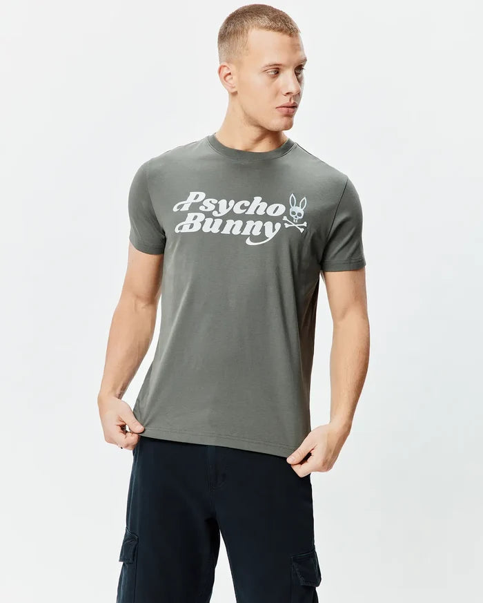 Dark grey classic fit jersey Mens Byron Wordmark Tee with a prominent white Psycho Bunny wordmark and iconic bunny skull logo graphic on the chest.