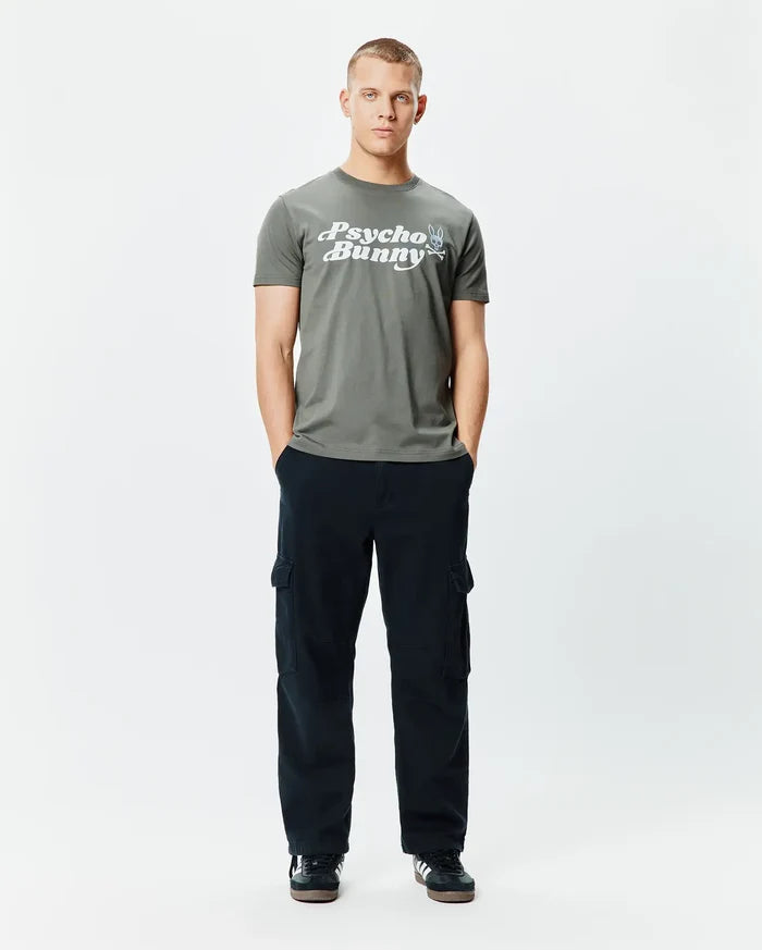 Mens Byron Wordmark Tee, a classic fit olive green jersey t-shirt with a large white Psycho Bunny wordmark graphic and blue-eyed skull logo on the chest.