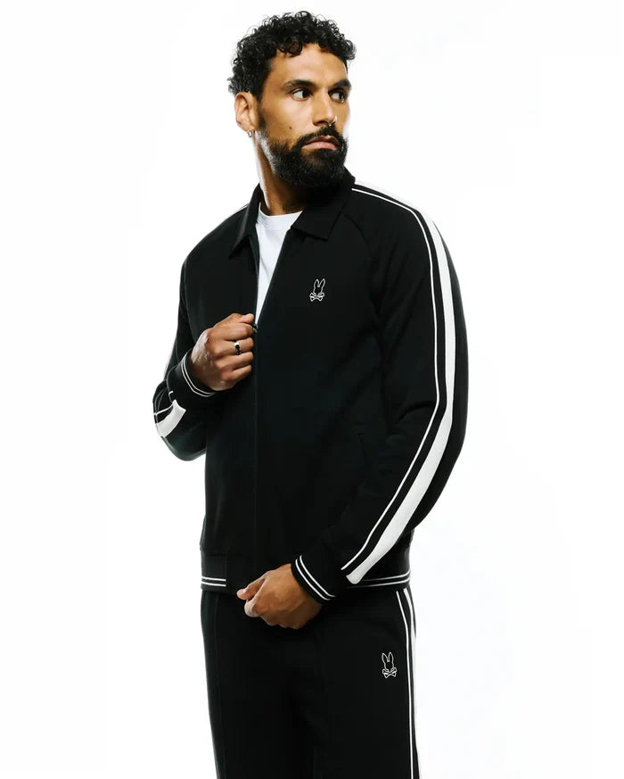 Mens Ceano Track Jacket in black smooth knit, featuring a classic fit, full zip, double white stripes on sleeves, ribbed cuffs and hem, and a small embroidered white Psycho Bunny skull logo on the left chest.